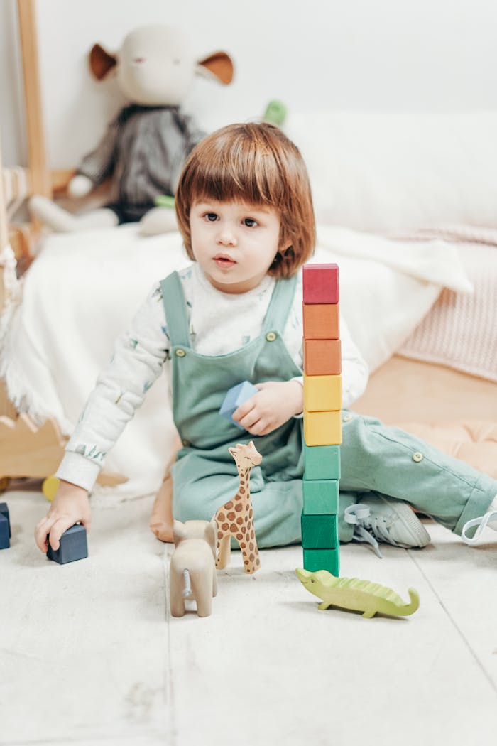 Adorable toddler playing with colorful wooden blocks and toys in a cozy playroom setting.